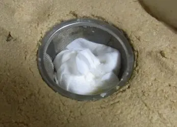 茶こしで作ったぬか床の穴に水分を集めて水けを取る
